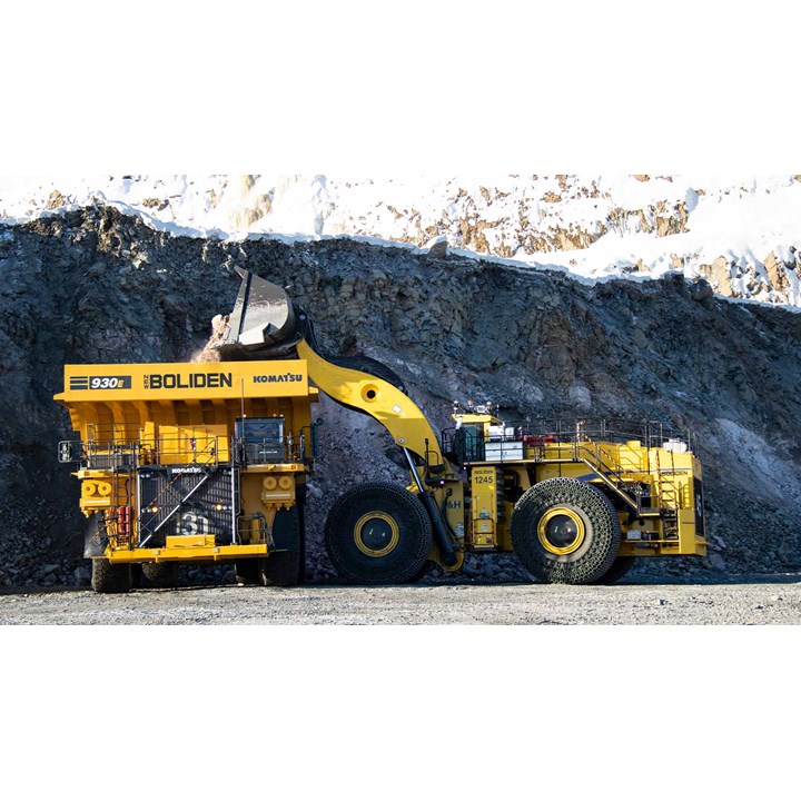 Keltainen kaivoskuorma-auto ja kaivinkone kallioisella louhintatyömaalla.