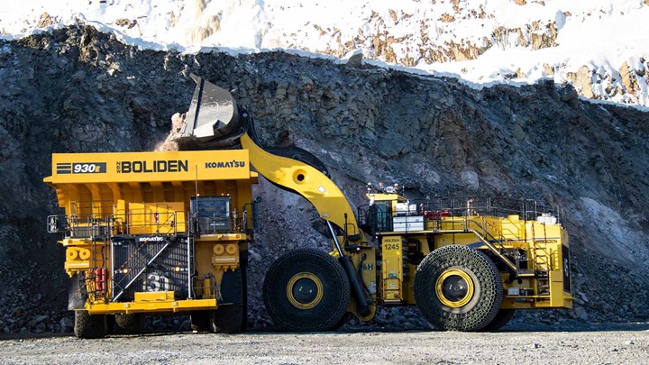 Yellow mining dump truck and excavator at a rocky excavation site.